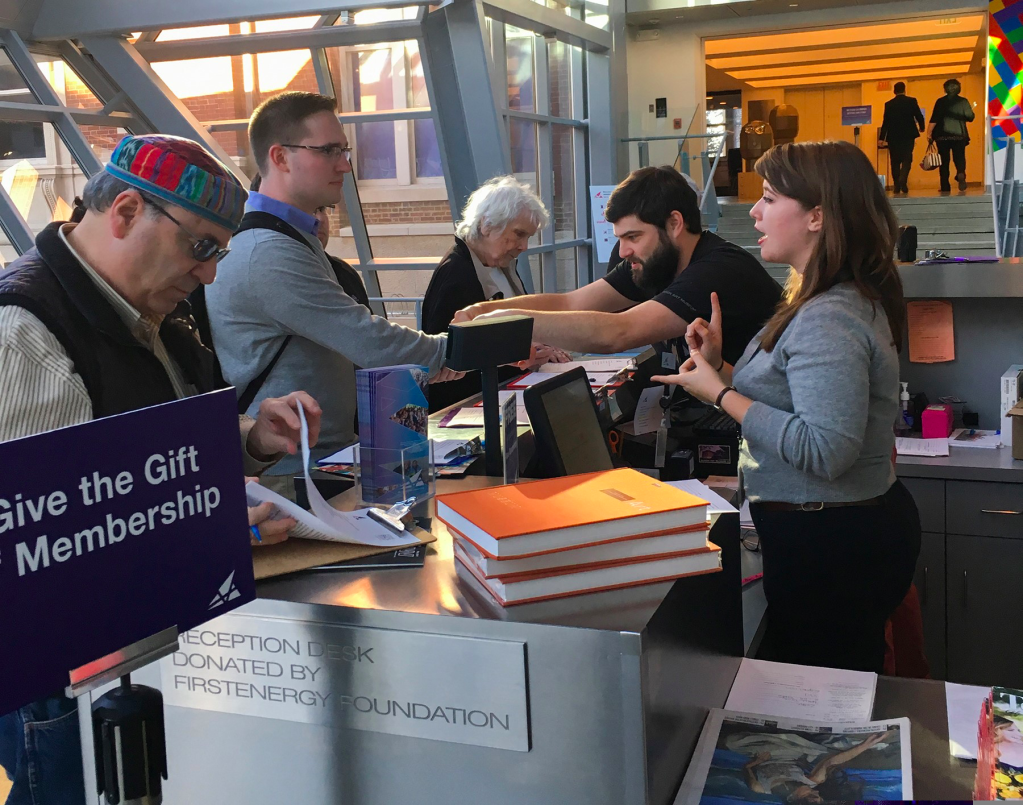 Staff receiving guests behind an admissions desk