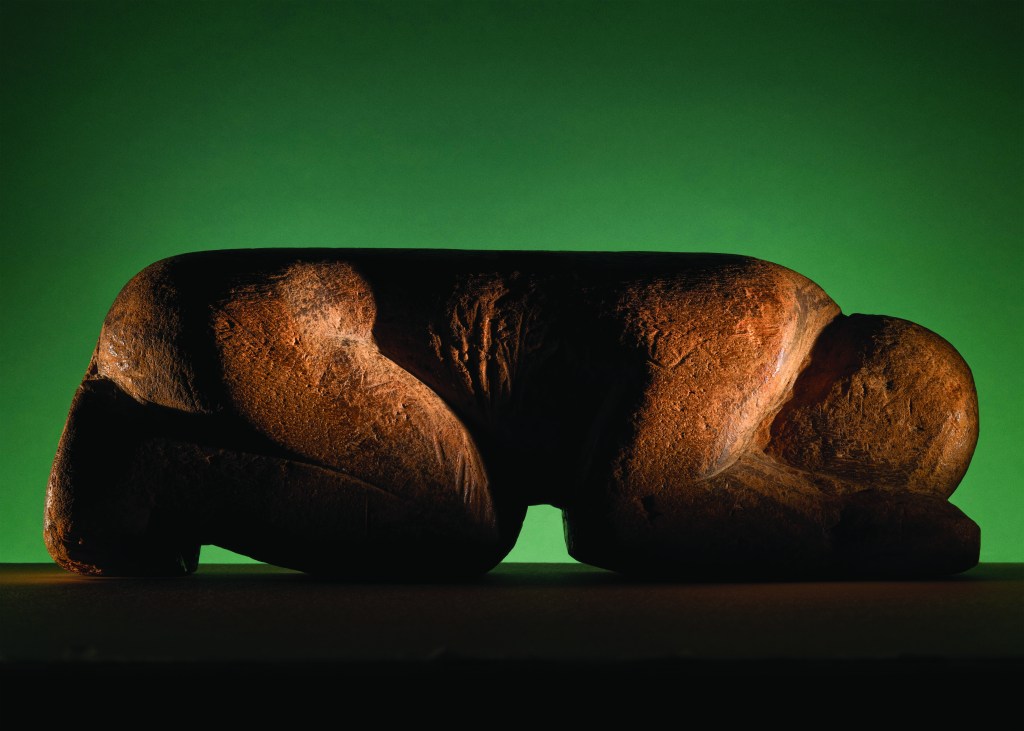 A sculpture of a kneeling human figure